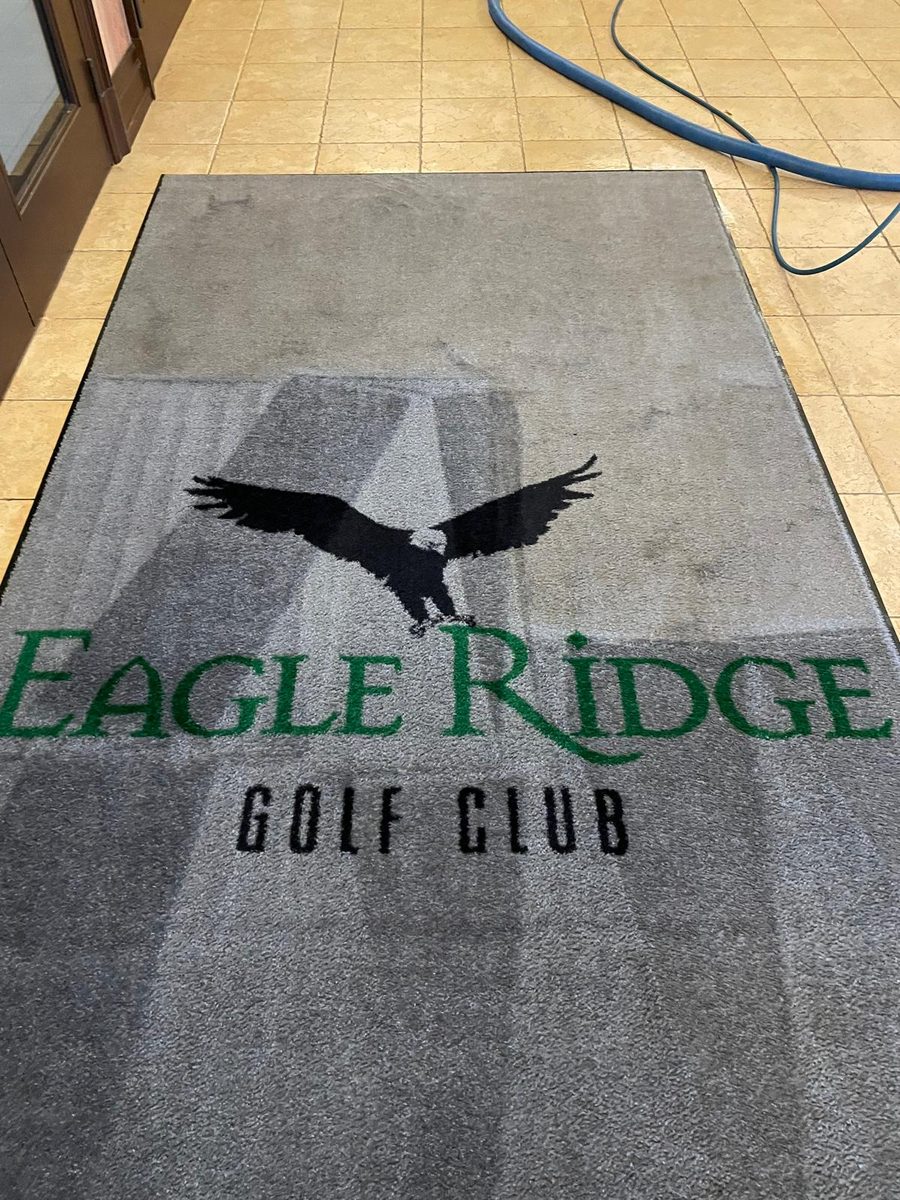 Eagle Ridge Golf Club logo entrance mat with the top half cleaned to a lighter grey and the lower half still darkened